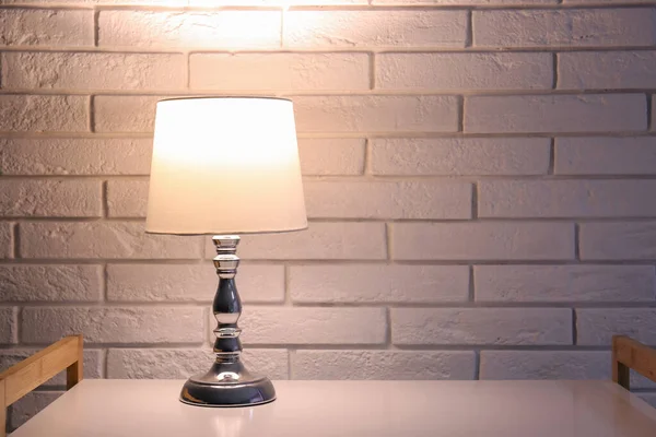 Светящаяся Лампа Полке Возле Белой Кирпичной Стены Темной Комнате — стоковое фото