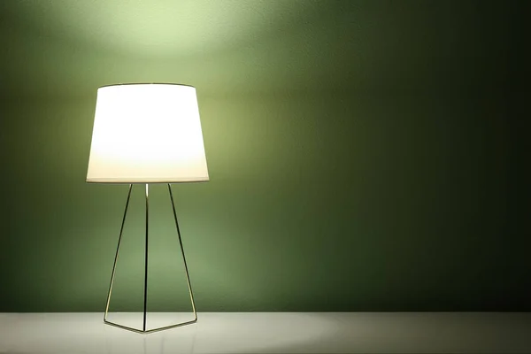 Lampe Lumineuse Sur Table Près Mur Vert Dans Pièce Sombre — Photo