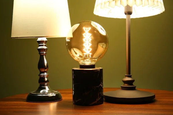 Karanlık Odadaki Ahşap Masada Farklı Parlayan Lambalar — Stok fotoğraf