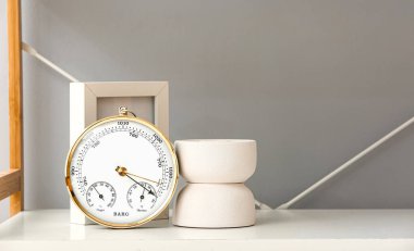 Beyaz masadaki aneroid barometre, yakın plan.