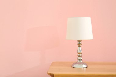 Lamba, pembe duvarın yanındaki ahşap masada.