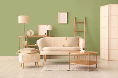 Oturma odasında rahat bir kanepe, puf ve sehpa var.