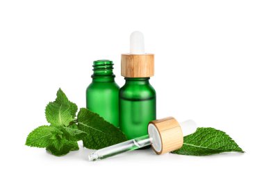 Önemli yağ şişeleri ve beyaz zemin üzerinde taze nane.