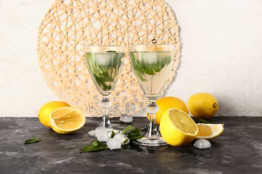 Karanlık masada soğuk mojito ve limon bardakları.