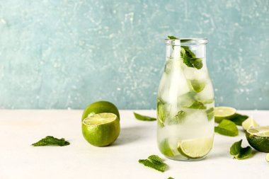 Bir şişe soğuk mojito, nane yaprağı ve limon.