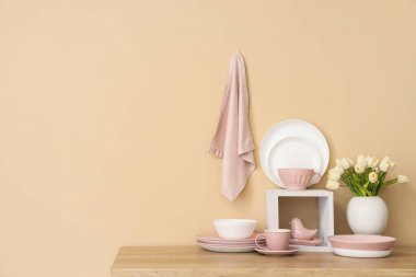 Ahşap tezgahta lale çiçekli temiz tabak ve vazo takımı.