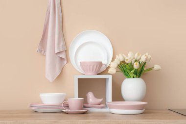 Ahşap tezgahta lale çiçekli temiz tabak ve vazo takımı.