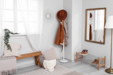 Ayna, askı ve ayakkabı standı olan ışık koridorunun içi