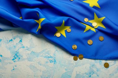 Coins and European Union flag on blue background