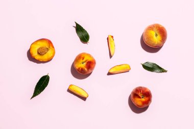 Tatlı şeftali ve yapraklar pembe arka planda