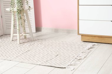 Oturma odasının içinde, taburesi ve şık halısı olan bir ev.