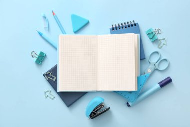 Mavi zemin üzerinde boş defter ve farklı okul sayfası olan kompozisyon