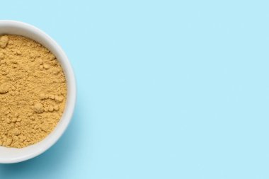 Mavi arka planda zencefil tozu olan kase