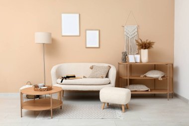 Interior of stylish living room with blank frames, table and sofa