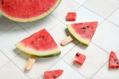 Hafif fayans zemininde lezzetli karpuz çubukları olan kompozisyon, yakın plan.