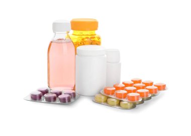 Beyaz arka planda farklı haplar ve ilaç şişeleri