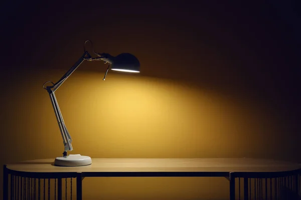 暗い部屋の木のテーブルの光るランプ — ストック写真