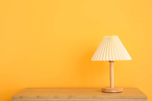 橙色墙壁附近木制桌子上的灯 — 图库照片