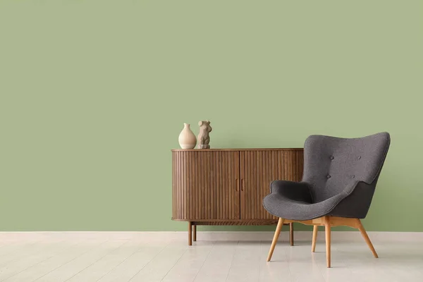 Grauer Sessel Und Holzschrank Neben Grüner Wand — Stockfoto