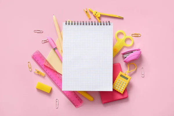 粉红背景的空白笔记本和不同学校文具的构图 — 图库照片