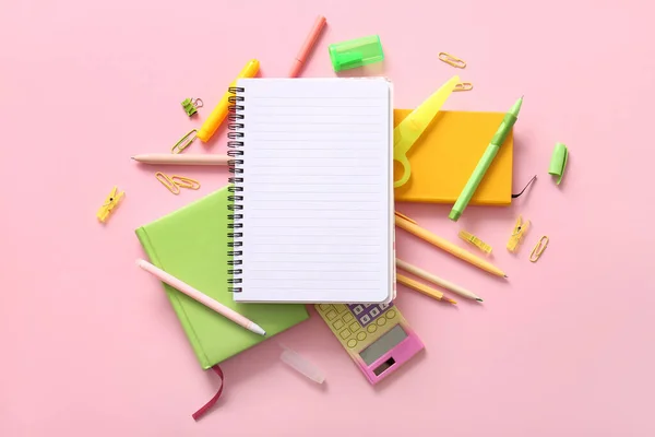 ピンクの背景に空白のノートと別の学校の文房具が付いている構成 — ストック写真