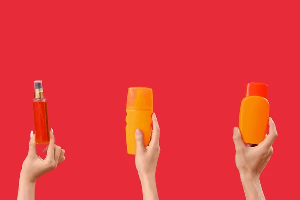 Female Hands Bottles Sunscreen Cream Red Background — Stock Photo, Image