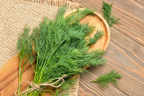 Ahşap arka planda taze dereotu olan bir tahta.