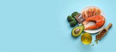 E vitamini bakımından zengin tabaklar ve metin için alanı olan açık mavi arka planda haplar.