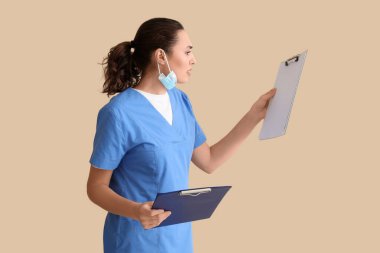 Bej arkaplanı olan bir kadın tıbbi asistan.