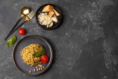 Lezzetli makarna tabağı ve koyu grunge arka planda domatesler.