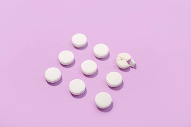 Eflatun arka planda beyaz haplar