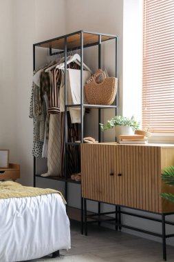 Raflar ve kıyafetlerle aydınlık yatak odasının içinde.