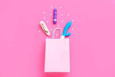 Vibratörlü alışveriş çantası ve pembe arka planda kalpler.
