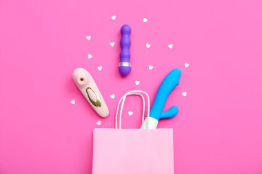 Vibratörlü alışveriş çantası ve pembe arka planda kalpler.