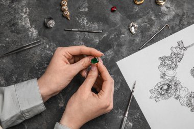 Yüzüğü karanlık masada, yakın plan kadın kuyumcu.