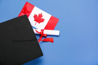 Mezuniyet şapkası ve mavi arka planda diploması olan Kanada bayrağı