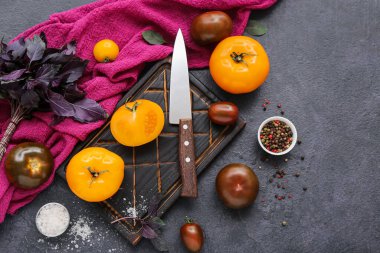 Koyu arkaplanda farklı taze domatesler olan tahta.