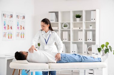 Rehabilitasyon merkezinde genç bir adamla çalışan kadın fizyoterapist.