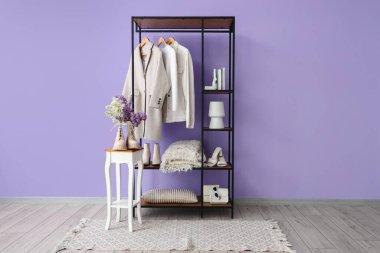 Raflar, giysiler ve taburesi olan şık bir oda.