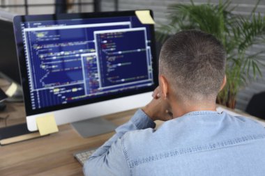 Olgun erkek programcı ofiste çalışıyor.