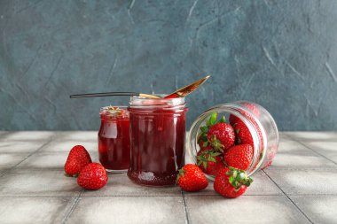 Kavanozlar dolusu tatlı çilek reçeli ve taze böğürtlen.