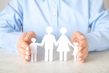 Beyaz masada insan figürleri olan bir kadın. Aile sevgisi kavramı