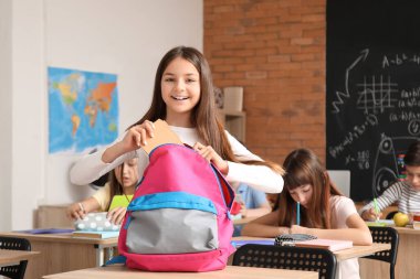 Sınıfta sırt çantalı küçük kız.