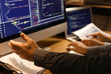 Geceleri ofiste çalışan erkek programcı, yakın plan.