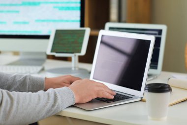 Ofiste dizüstü bilgisayarla çalışan erkek programcı, yakın plan.