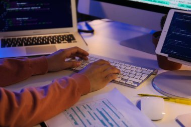 Gece ofiste bilgisayarla çalışan kadın programcı, yakın plan.