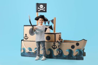 Mavi arka planda kılıcı ve karton gemisi olan sevimli küçük bir korsan.