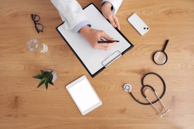 Doktor ahşap masadaki panoyla çalışıyor.