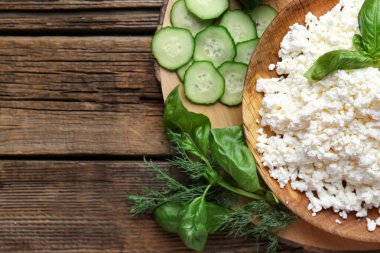 Ahşap masada salatalık, fesleğen ve dereotlu taze süzme peynir
