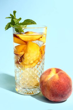 Mavi arka planda naneli taze şeftali limonatası.